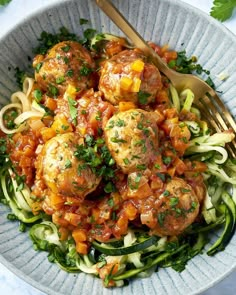 a bowl filled with meatballs and zucchini noodles