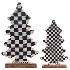 two black and white checkered christmas trees on wooden bases, each with a different design