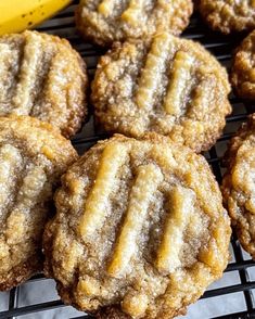 several cookies on a cooling rack next to a banana