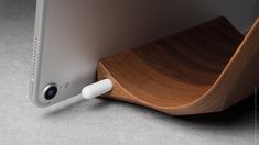 an electronic device is plugged into a wooden stand