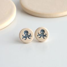 the earrings are decorated with an octopus on it's earring backs and blue ink