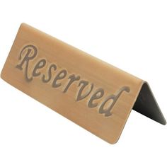 a wooden sign that says reserved on the front and back of it's holder