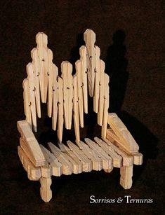 a group of wooden people sitting on top of a bench made out of wood planks