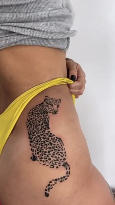 a woman's stomach with a tattoo of a cheetah on the side