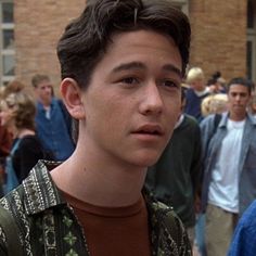 a young man standing in front of a crowd of people