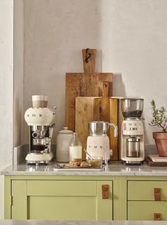 a kitchen counter with various coffee makers and pots on it, including an espresso machine