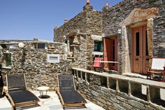 two lawn chairs sitting on top of a stone building