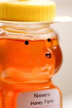 a glass jar filled with honey sitting on top of a table