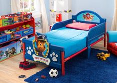 a child's bedroom with blue walls and wooden floors, including a toy bed