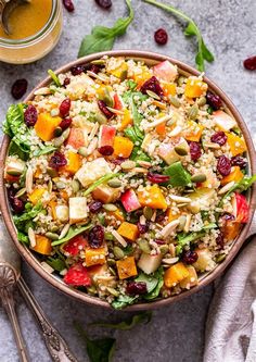 a bowl filled with rice, cranberries and other food on top of a table