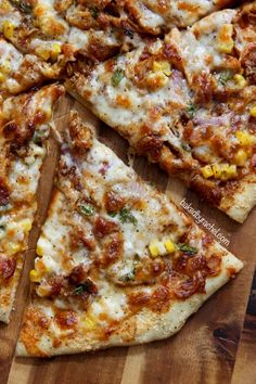 a pizza cut into four pieces on top of a wooden cutting board