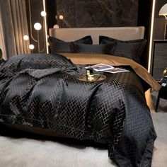 a bed with black and gold comforter in a bedroom next to a night stand