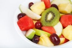 a fruit salad with kiwi, oranges, grapes and pomegranate