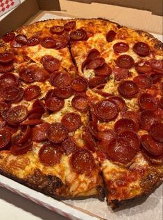 a large pepperoni pizza in a box on a table