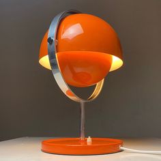 an orange lamp sitting on top of a white table