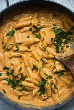 a skillet filled with pasta and garnished with parsley