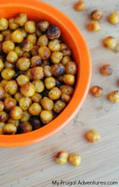 a bowl filled with nuts sitting on top of a wooden table