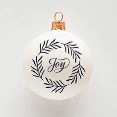 a white ornament with the word joy on it