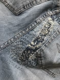 the back pocket of a pair of jeans with an embroidered design on it's side