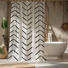 a white tub sitting next to a shower curtain with black arrows on it in a bathroom