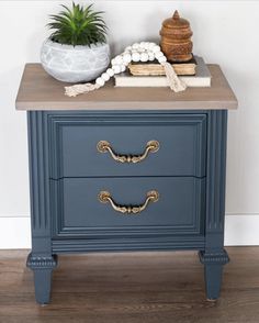 a blue nightstand with two drawers and a potted plant on top