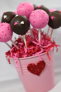 pink and black cake pops in a bucket