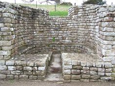 an old stone wall with benches in the middle