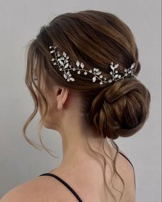 a woman wearing a bridal hair comb with leaves on it's head and pearls in her hair