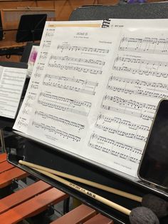 sheet music is being played on an electronic device in a room full of musical instruments