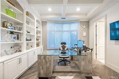 a home office with built in shelving and desk