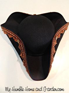 the back of a black hat with gold trim