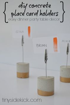 three small concrete holders with clothes pins in them and the words diy concrete place card holders