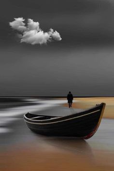 a boat sitting on top of a beach next to the ocean under a cloudy sky