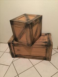 two wooden boxes stacked on top of each other in the middle of a tiled floor