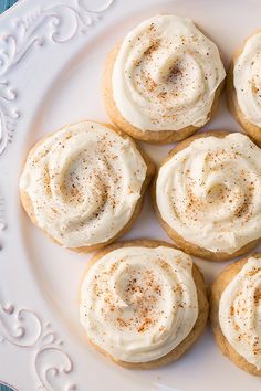 several cookies with white frosting and cinnamon sprinkles are on a plate