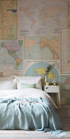 a bed sitting in a bedroom next to a wall with maps on it