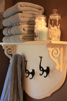 towels and candles are sitting on a shelf