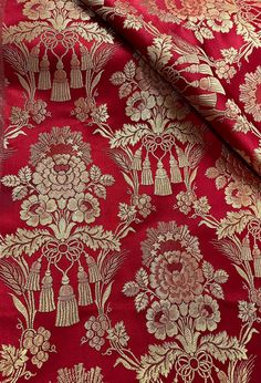 a red and gold brocade with flowers on it