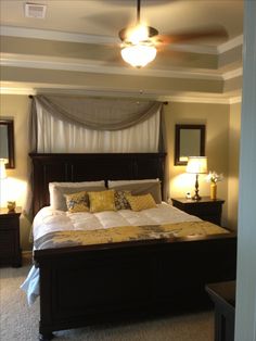 a bedroom with a bed, dressers and two lamps on either side of the bed