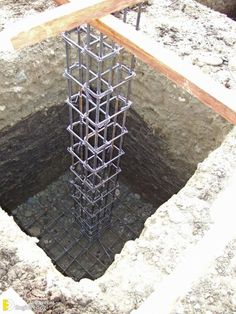 a large hole in the ground that is filled with cement and steel bars are sticking out of it