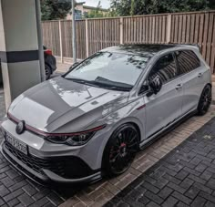 a grey car is parked on the side of the road