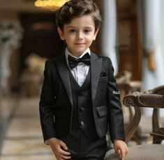 a young boy in a tuxedo and bow tie