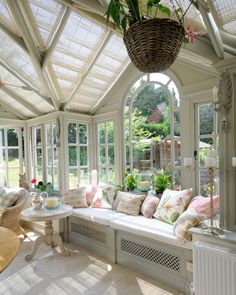 a sun room with lots of windows and furniture