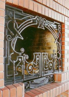 a brick fireplace with an ornate iron grill