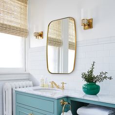 a bathroom with blue vanity and gold accents