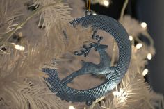 a silver ornament hanging from a christmas tree