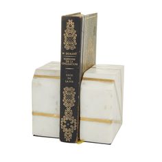 two books are stacked on top of each other, one is black and white with gold trim