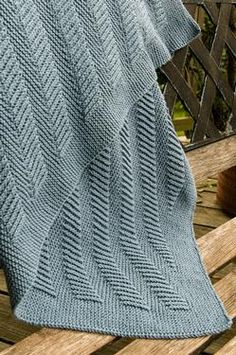 a blue blanket sitting on top of a wooden bench