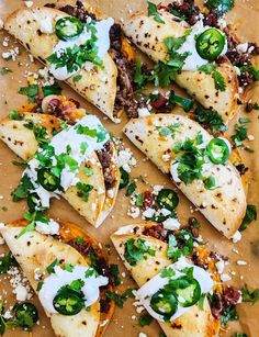 several quesadillas with cheese and toppings on a cutting board