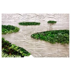 an artistic wall sculpture with green plants growing on it's sides and flowing water in the middle